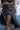 Black leather single-pocket belt with stud details and flap pocket, worn over a Runic Chinatsu Ruffle Skirt