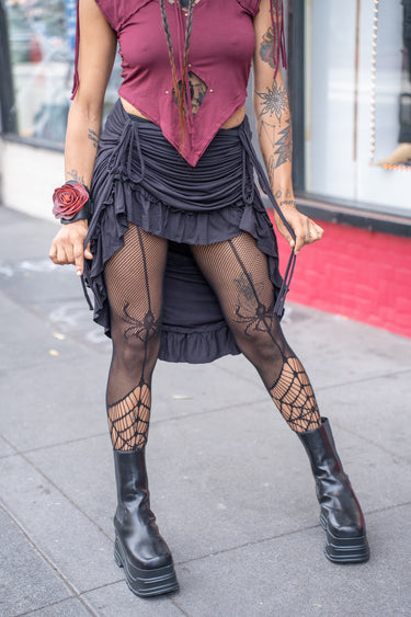 Black Ruffle Long Skirt with adjustable front cinch and ruffled hem, modeled outdoors