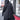 Back view of the black Runic Cardigan showing the hood, tonal print, and asymmetric hem.