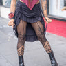 Black Ruffle Long Skirt with adjustable front cinch and ruffled hem, modeled outdoors