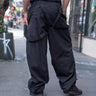 Unisex Combat runic Pants in black with tonal Runic print and buckle straps, back view