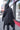 Back view of the black Runic Cardigan showing the hood, tonal print, and asymmetric hem.